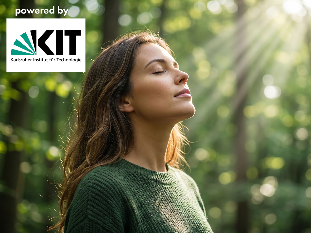 Woman with eyes closed enjoying sunlight in a green forest, wearing a green sweater; KIT logo and 'powered by' appear in the top-left corner.