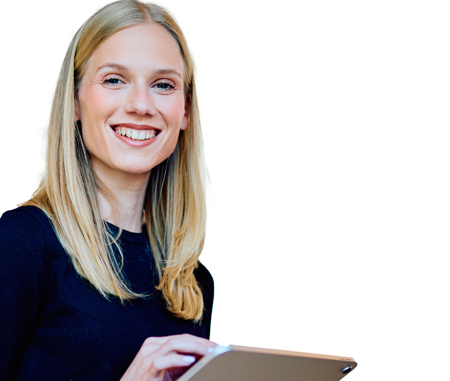 Smiling blonde woman in a navy sweater holds a tablet in a bright office setting.